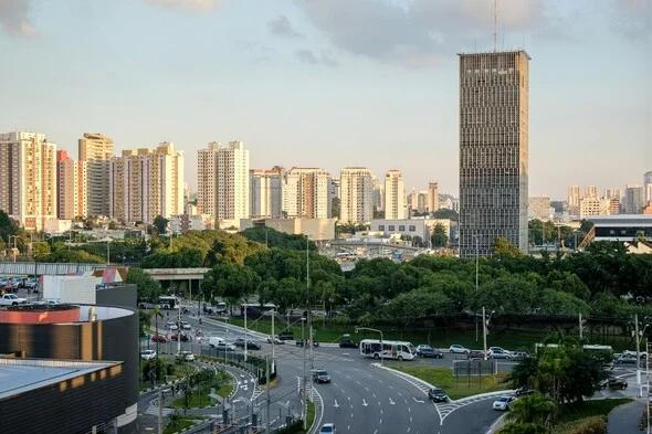 Vista da cidade de São Bernardo do Campo com prédios ao fundo enquanto carros passam por uma rua